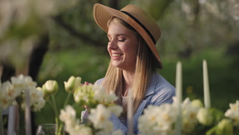 joyful-woman-in-straw-hat-is-sitting-at-table-in-garden-laughing-and-joking-happiness-and-enjoy-life